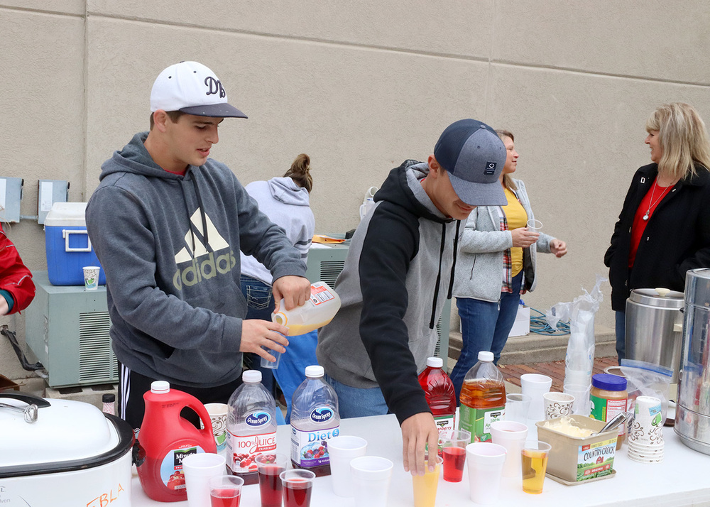 Seniors Mitchell Budke and Taylor Palenske pour juice for the FBLA pancake feed. Photo by Linda Drake