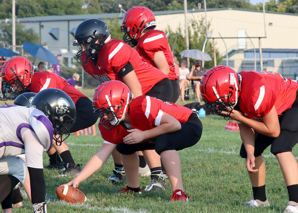 Football players line up for beginning play. Photo by Kinslea Glanville