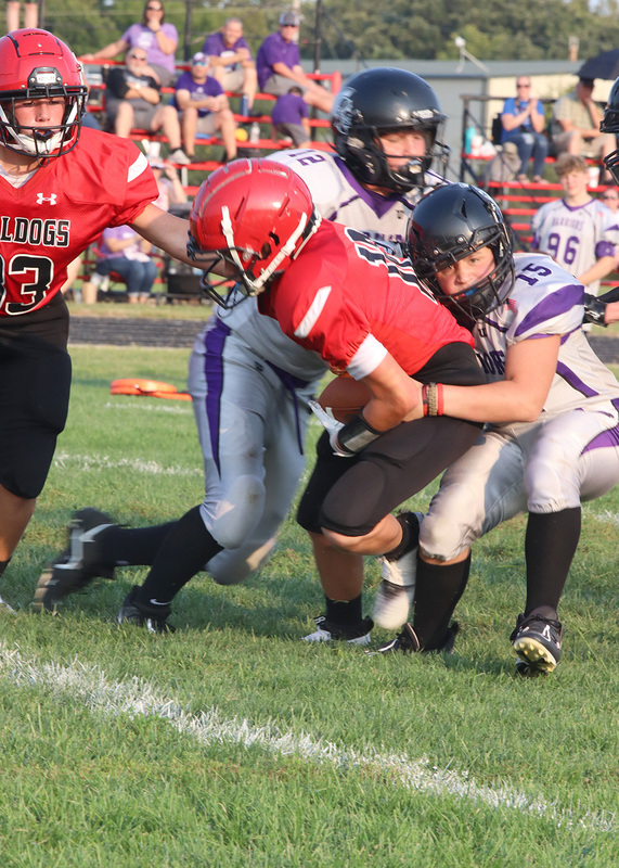 Number 12 Clark Miller is tackled by opposing team. Photo by Kinslea Glanville