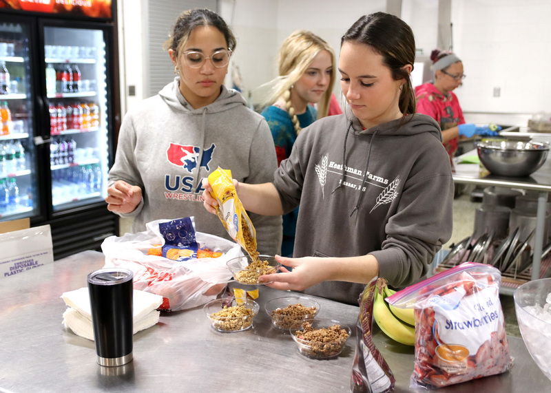 Seniors Grace O'Brien and Avia Banks pour granola for the staff breakfast. Photo by Linda Drake