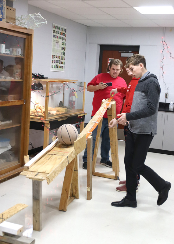 Junior Tag Groh and senior Jake Sollner finish setting up the Rube Goldberg machine. Photo by Linda Drake