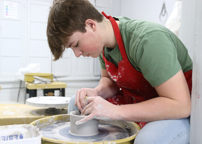 Senior James Bell concentrates on perfecting the shape of his clay pot. Photo by Abby Jones